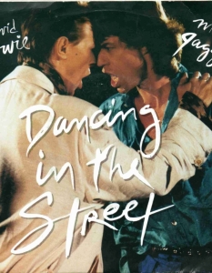 Мик Джагър и David Bowie
Dancing in the Street
Съвместната песен на Мик Джагър и David Bowie - Dancing in the Street, добива голяма популярност, но тя не отнема от абсурдността, в която са се оплели двете звезди във видеоклипа към парчето. Dancing in the Street е кавър на 60-арски Motown хит, тотален разбивач е в ефира на радиостанциите в средата на 80-те години, както и част от благотворителната кампания Live Aid, но и тук редица нелепости създават смущения по трасето към реалността. В клипа, Мик Джагър и David Bowie са облечени от глава до пети в крещящата визия на 80-те, чийто връх са жълтите обувки на фронтмена на The Rolling Stones, с които изглежда той обича да танцува по улиците. Иначе, Мик Джагър танцува като David Bowie, David Bowie танцува като Мик Джагър и то в шлифер. Изглежда така става, когато Кийт Ричардс не е наоколо.
