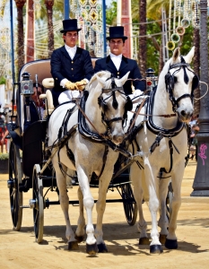 Хора се забавляват с разходка с класическа конна каляска пред The Royal Hpuse of The Fair в Jereez de la Frontera, Испания. 